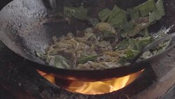 movie shot of a man cooking with charcoal stove. Noodle dish in wok made on open fire. Street food in Chinatown of Bangkok, Thailand Stock Footage