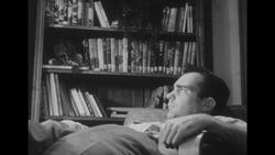 1950s: Restless husband sits in chair Stock Footage