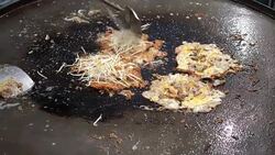 4k Cooking mussel fried in egg batter in hot flat pan Stock Footage