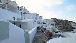 Traditional Greek flag with white Greek architecture overlooking the Aegean Sea in Oia Santorini Greece Stock Footage