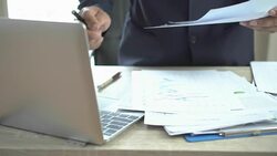 Document Report and business busy Concept: Businessman Manager checking and signing documents reports papers with calculator, laptop computer on stacks of paper files in modern office. Stock Footage