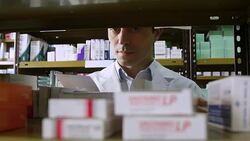 Mature pharmacist examining medicines on rack Stock Footage