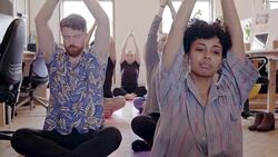 Serene creative business people practicing yoga in office Stock Footage