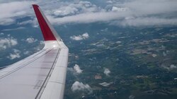Airplane flight. Wing of an airplane flying above the clouds from window plane view Stock Footage