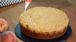 Cook decorating a cake with icing sugar with a piping bag. Summer peach pie with caramel sugar crumb Stock Footage
