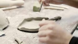 Hands making designs on leaf shape clay in studio Stock Footage