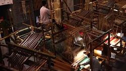 Craftsman working on huge old wooden brocade weaving looms Stock Footage