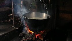 Steaming pot over indoor fire in mountain hut Stock Footage