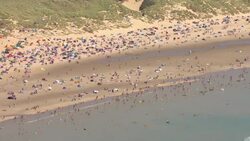 People on beach at Camber Sands on the hottest day in 17 years News Clip