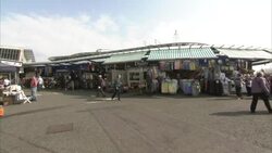 People shopping at an outdoor marketplace in Bury News Clip