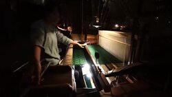 Craftsman working on huge old wooden brocade weaving looms Stock Footage