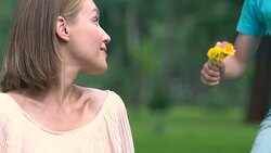 Child presenting field flowers to mother, sweet surprise, happy family in park Stock Footage