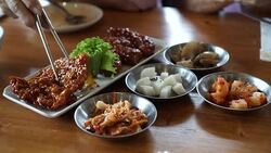 Eating Korean spicy sauce fried chicken with side dishes 4k Stock Footage