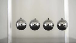 a pendulum with swinging metal spheres demonstrates conservation of momentum Stock Footage