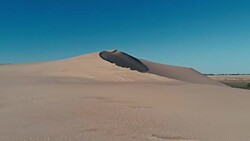 aerial footage a sand dune peak in a beautiful desert environment Stock Footage