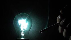 Smoking cigarettes against the backdrop of a glowing light bulb Stock Footage