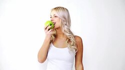happy beautiful young woman eating green apple Stock Footage