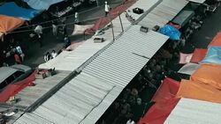 aerial drone footage of the morning city market with colorful tents looking down Stock Footage