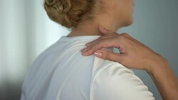Woman suffering shoulder pinched nerve and massaging painful body part, trauma Stock Footage