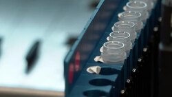 Lab assistants loading machine with test tubes News Clip