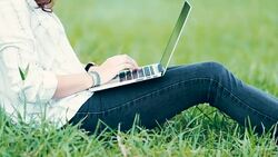 Woman using laptop in the outdoor garden, slow motion Stock Footage