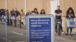 UK: Shoppers socially distancing outside Tesco supermarket in Osterley. News Clip