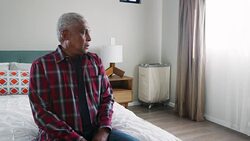 Senior man suffering with depression sitting in bedroom at home - shot in slow motion Stock Footage