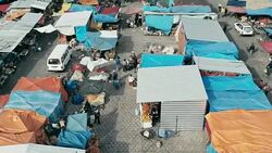 aerial drone footage of the morning city market with colorful tents looking down Stock Footage