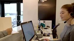 Female nurse writing in medical chart and talking to receptionist in clinic Stock Footage