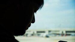 Young Asian man using mobile phone touchscreen and talking on phone. working on the phone, in the background of a Airport , planes, Concept: new business, travel, communication. Stock Footage