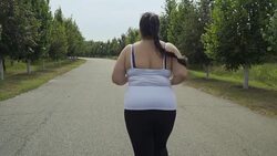 Fat girl runs along the road Stock Footage