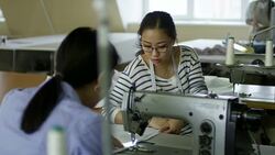 Women Talking when Sewing Clothes with Machine Stock Footage