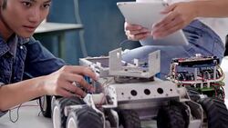 Teenage works on a fully functional programable Robot for robotics club project.Creative designer testing robotics prototype in workshop.Science concept Stock Footage