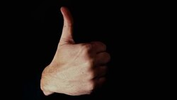 Hand appearing with a positive and large thumbs up signal Stock Footage