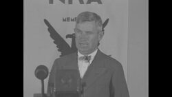 Will Rogers at microphone in front of NRA banner News Clip