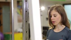 A slender strong girl trains a triceps in a crossover in the gym. Stock Footage