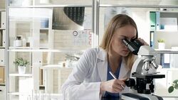 Woman in Lab Coat Using Microscope Stock Footage
