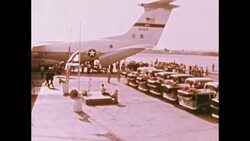 Military plane on ground. Men carry coffin to plane. Munich Airport sign on building, 1972 Stock Footage