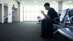 Young Asian man using mobile phone touchscreen and talking on phone. working on the phone, in the background of a Airport , planes, Concept: new business, travel, communication. Stock Footage