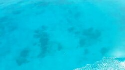 View from top at crystal clear blue water surface. Loop ready animation of moving water. Stock Footage