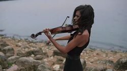 Elegant girl with violin. Brunette violinist in dress plays at sea background Stock Footage