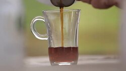 Lady pouring freshly made herbal tea through sieve, relaxing in middle of day Stock Footage
