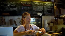 Beautiful waitress packing a sweet pastry to go for a customer Stock Footage