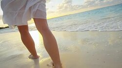 Legs of barefoot Caucasian female enjoying island sunset Stock Footage