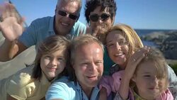 A big happy family takes a selfie or Uses Phone Video Call Camera on the seacoast. Stock Footage