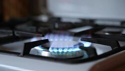 Stove top burner igniting into a blue cooking flame Stock Footage
