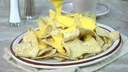 Pouring cheese sauce on nachos Stock Footage