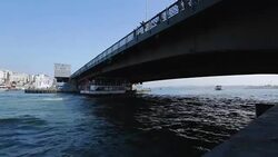 Full of tourists cruiser sailing under bridge, people fishing, boat tour Stock Footage