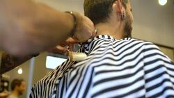 Barber trimming neckline of customer in salon Stock Footage