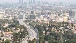 Time-lapse aerial view of Los Angeles Skyline building and freeway to downtown sunset Stock Footage